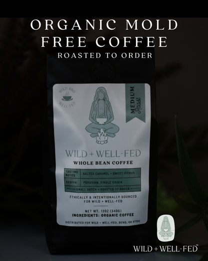 Wild + Well Fed coffee package with text about organic mold-free coffee on a dark background