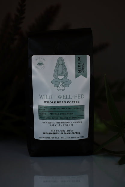 Coffee bag with 'Wild + Well Fed' label on a dark background