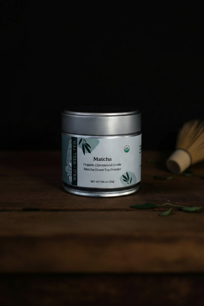 Matcha green tea powder canister on a wooden surface with a dark background