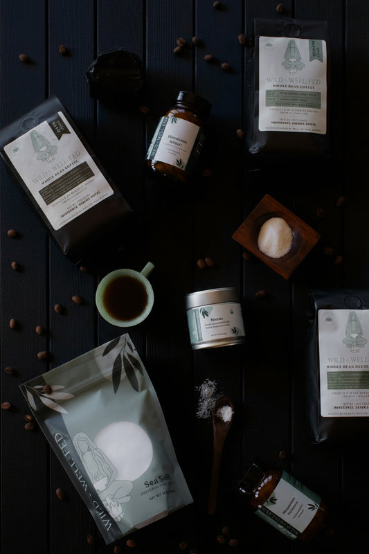 Collection of natural products including tea packages, a cup, and a jar on a dark surface.
